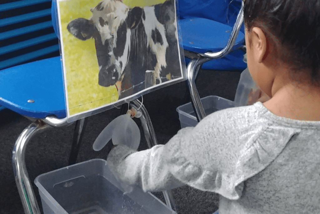 a girl pretending to milk a cow