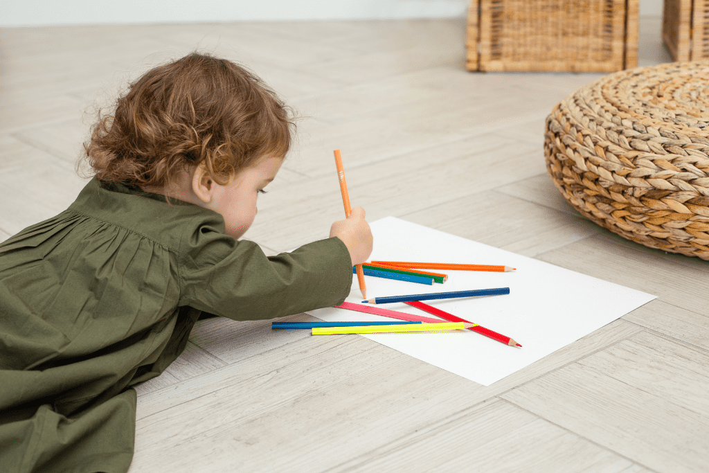 Preschool girl coloring with colored pencils.