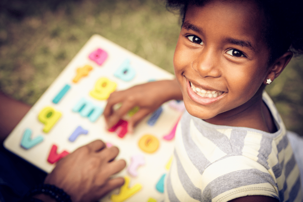 Preschool girl with alphabet puzzle