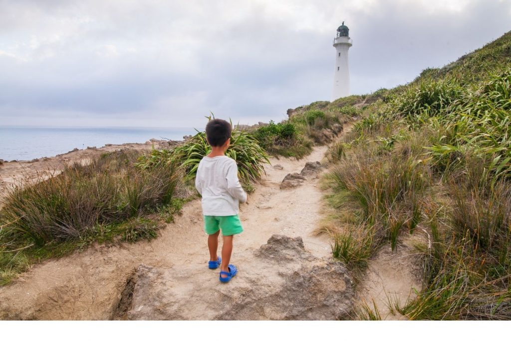 A boy looking at a lighthouse 
