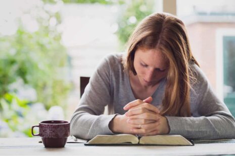 A woman praying with anopen bible