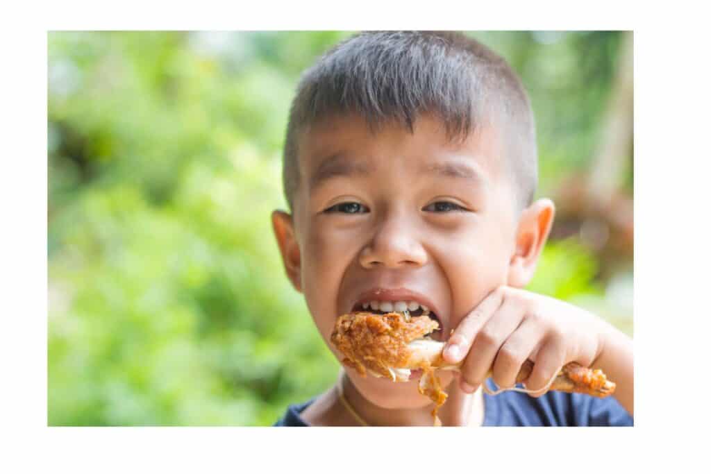 A boy eating fried chicken